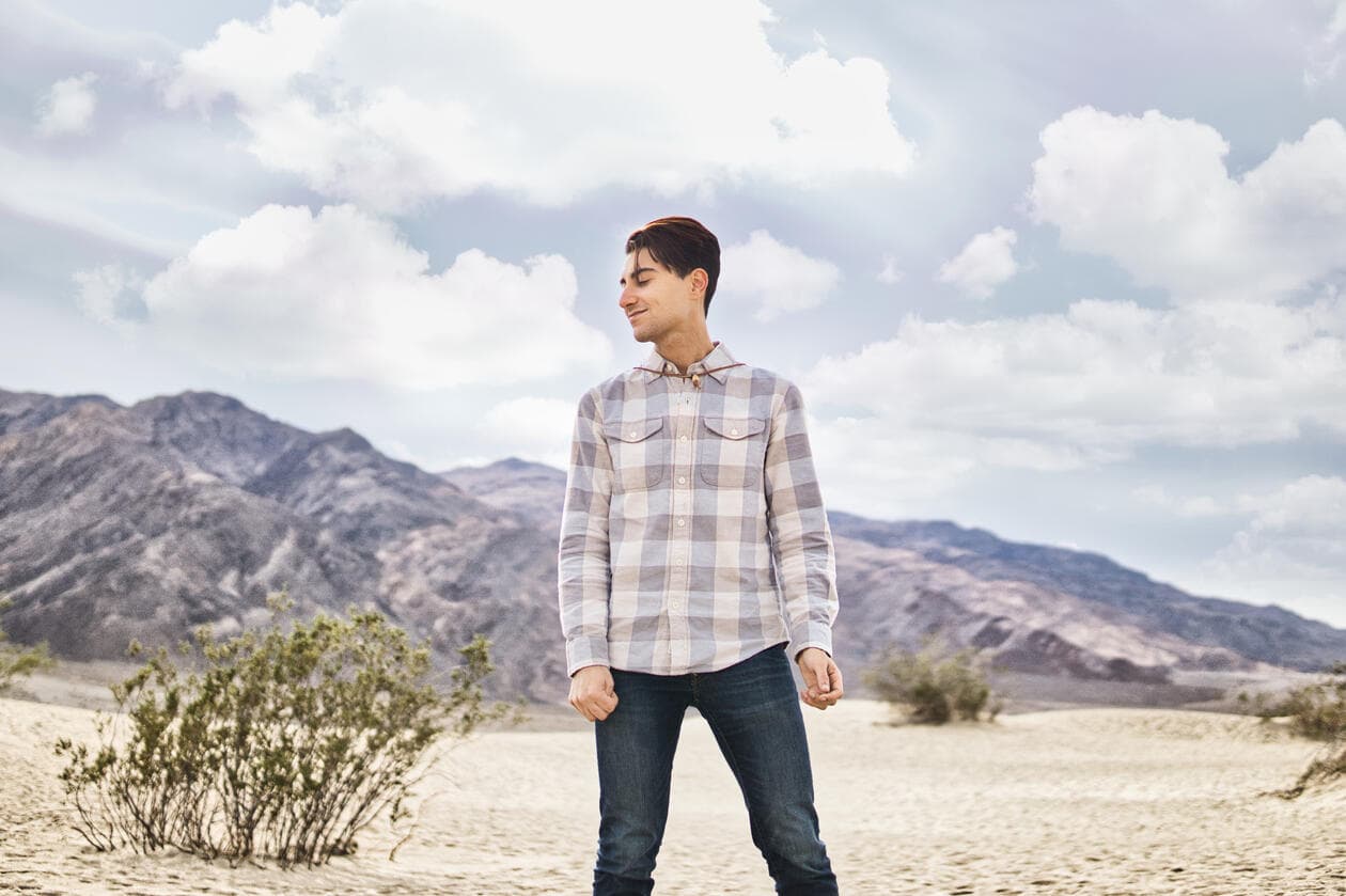 Dalton standing in the desert under a sky of clouds
